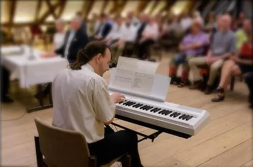 Fil spielt am weißen Stagepiano vor Gästen