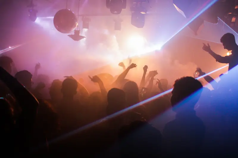 Volle Tanzfläche mit Laserlicht und Nebel
